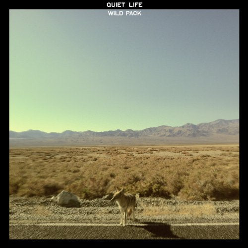 CD cover: desert landscape with a coyote standing on a road.