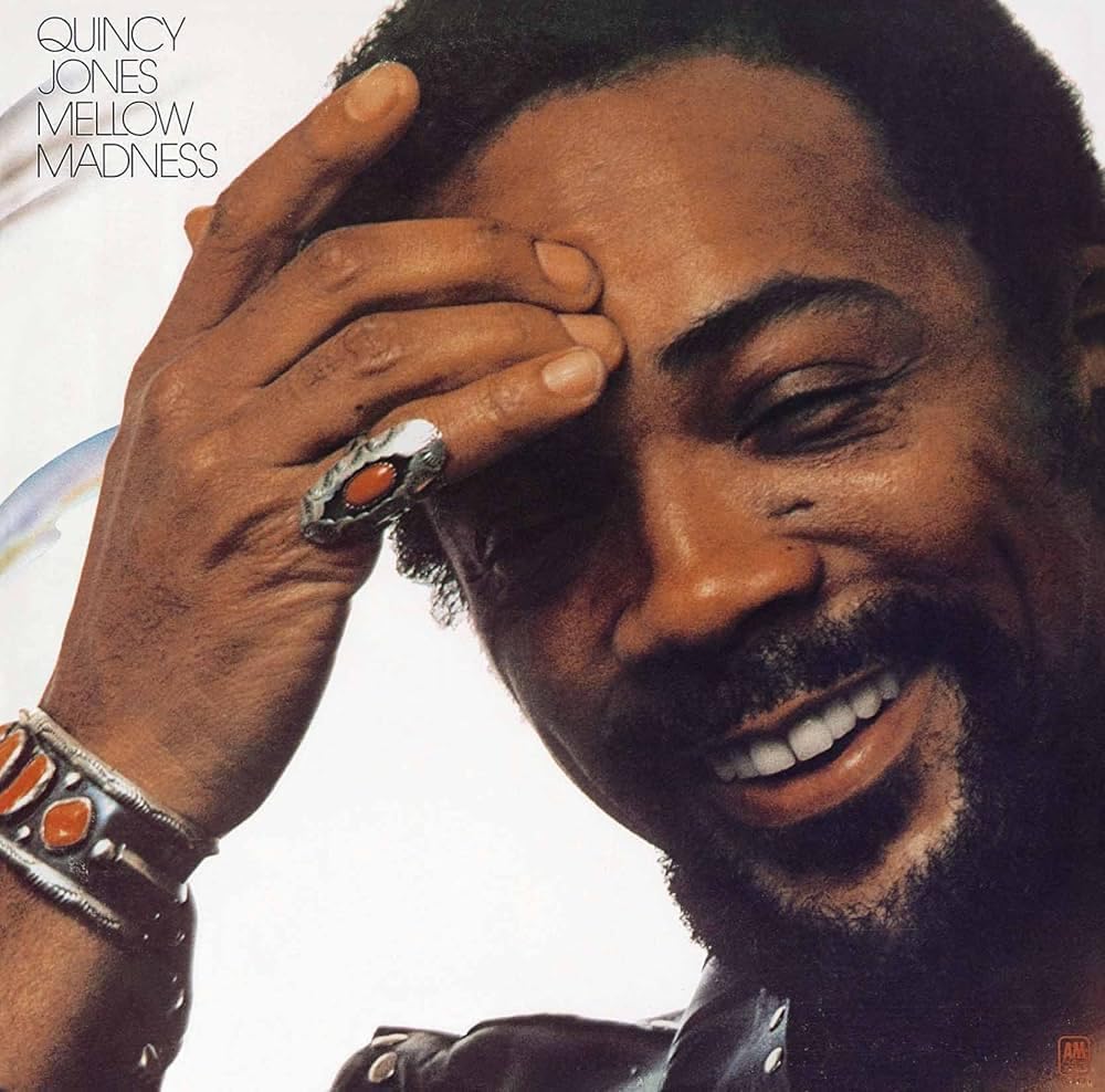 Quincy Jones smiling with hand to forehead on the Mellow Madness album cover.