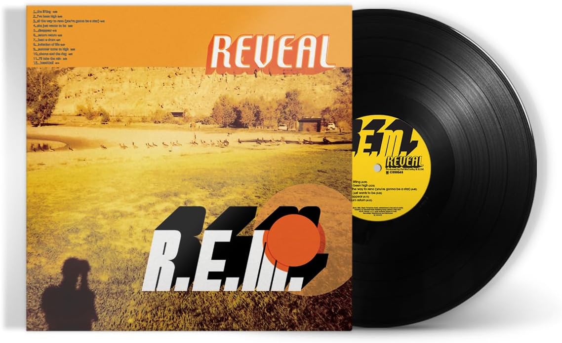 "Vinyl record with 'Reveal' album cover featuring a landscape and R.E.M. logo."