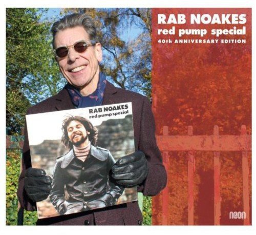 Rab Noakes holds his “Red Pump Special” album cover, wearing sunglasses.