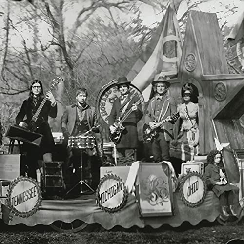 Black and white photo of The Raconteurs posing on a decorated float.