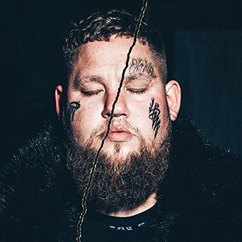 Rag'n'bone Man portrait with facial tattoos and a dark, textured background.