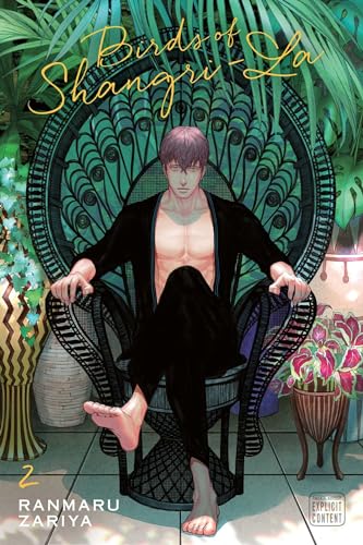 A man with short hair sits in a peacock chair surrounded by tropical plants.