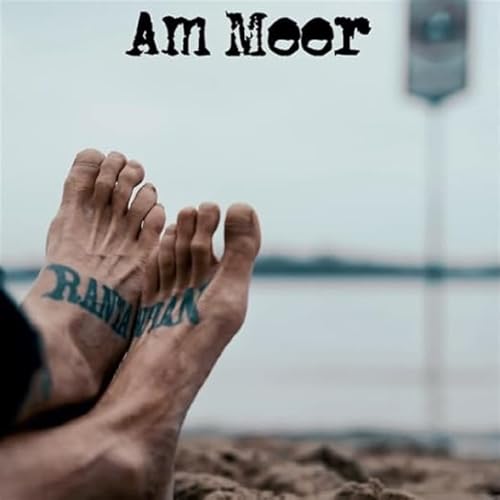Feet with tattooed name on sand near the sea.
