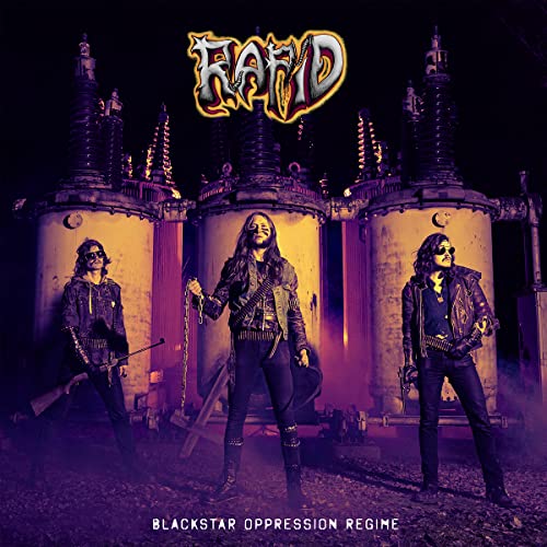 Three band members in leather jackets stand before industrial equipment under purple lighting.