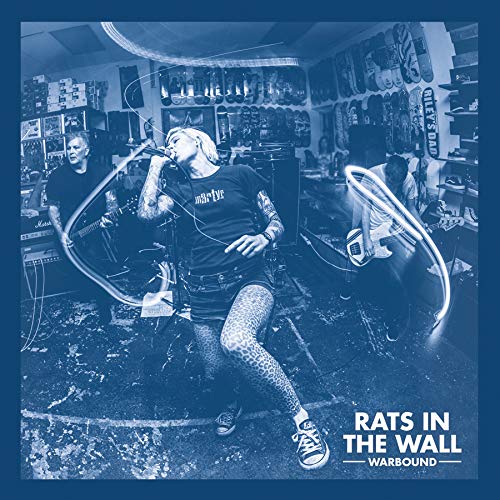 Band performing live in a cluttered room, album cover for Rats In The Wall.