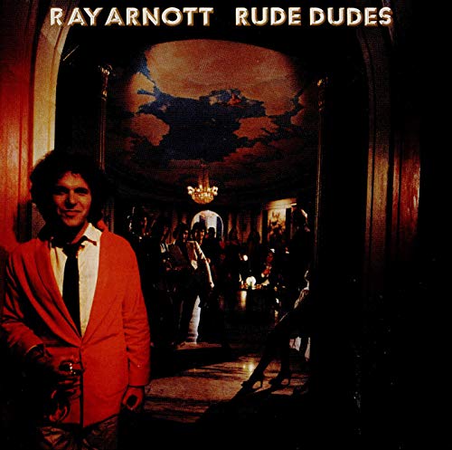 A man in a red jacket stands before a dimly lit, ornate interior hallway.