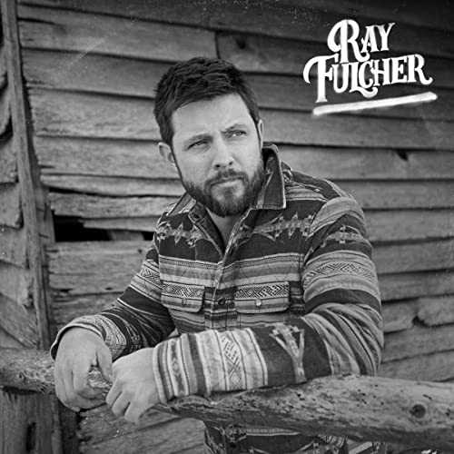 Black and white portrait of Ray Fulcher, wearing a patterned shirt.