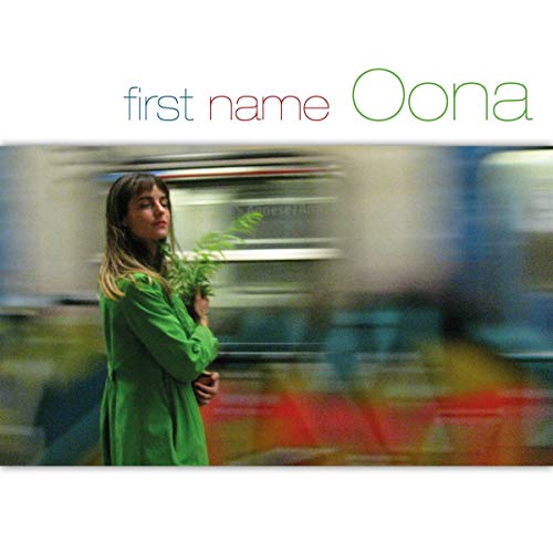 CD cover: woman in green holding plant, blurred motion background.