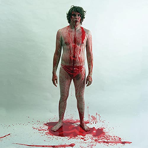 Man covered in red liquid stands on a red pool.
