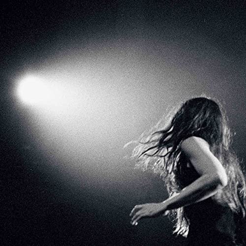 Black and white portrait of a woman with flowing hair, backlit.