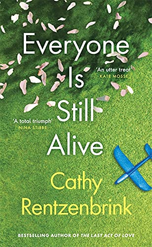 Book cover with title and author text over green grass, flower petals, and toy plane.