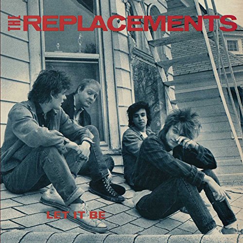 "Black and white album cover featuring four men sitting outside a house."