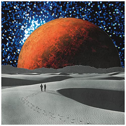 Two people walk across a desert landscape beneath a large orange planet and stars.