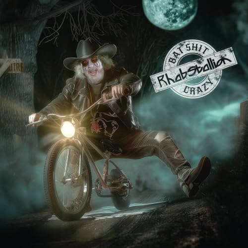 Man with a hat riding a motorcycle in a spooky forest.