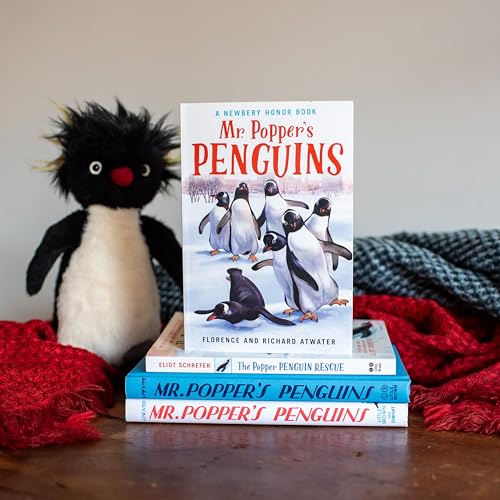 A copy of Mr. Popper's Penguins book stands on a stack with a penguin plush.