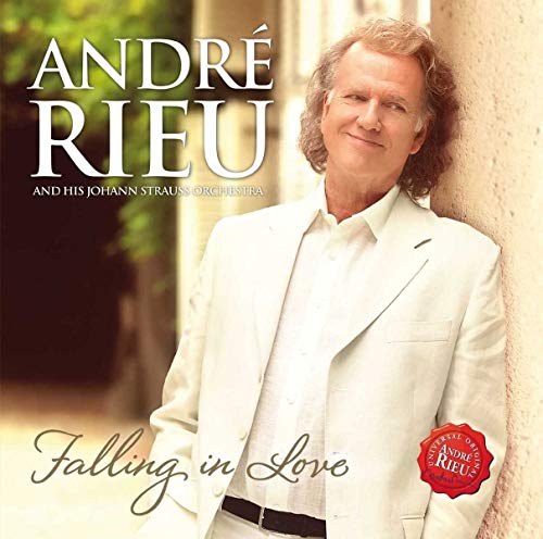 Man in white suit leaning on wall with text Andre Rieu Falling in Love.