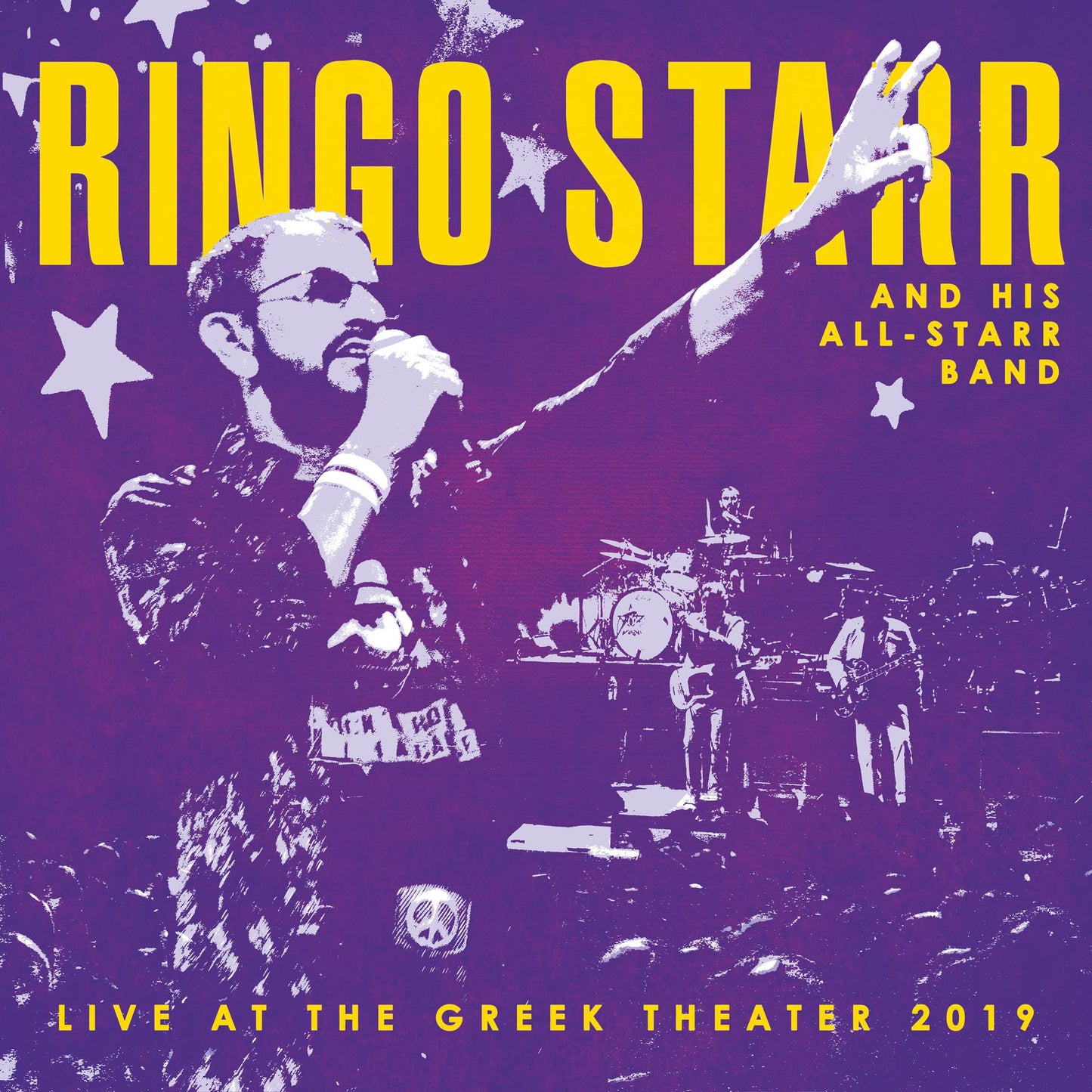 Ringo Starr performing live on stage with his band on a purple background.