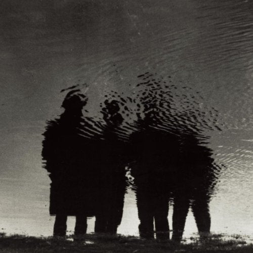 Black and white silhouette of three people reflected in rippled water.