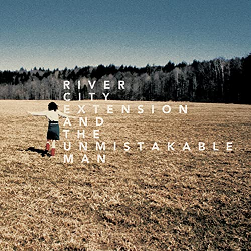 CD cover: man in a field with text and forest backdrop.