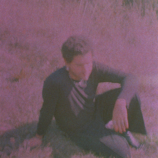 Purple-toned album cover featuring a person lying in grass.