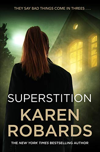 Book cover: woman facing a dark, lit house, title "Superstition" by Karen Robards.