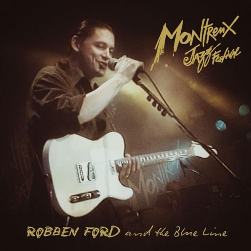 Robben Ford singing and playing a white electric guitar on stage at Montreux Jazz Festival.