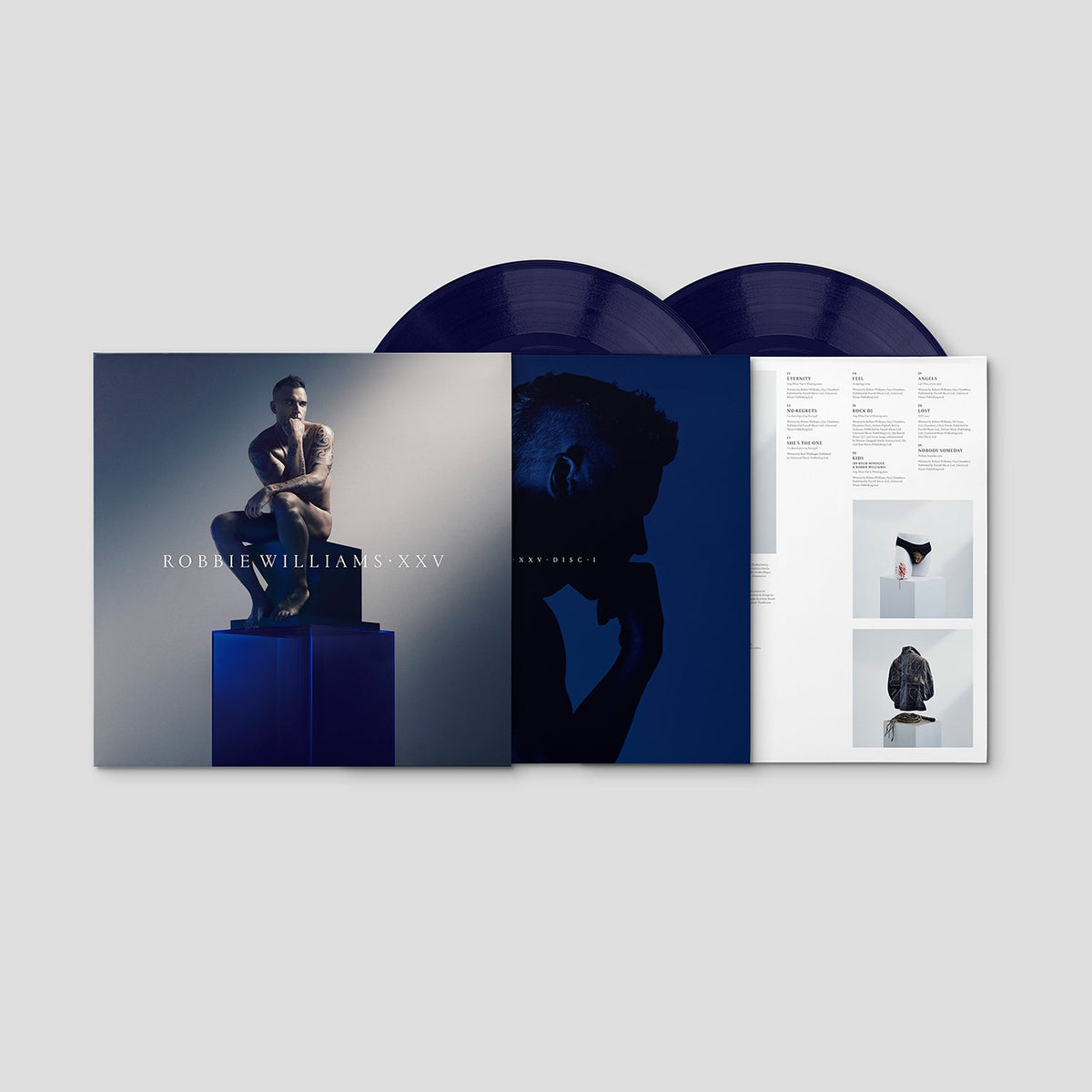 Robbie Williams XXV vinyl record with blue cover and booklet.