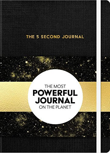 Black journal with gold lettering and a circular gold and white sticker.