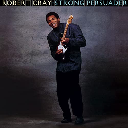 Robert Cray smiling, playing a white electric guitar on album cover.