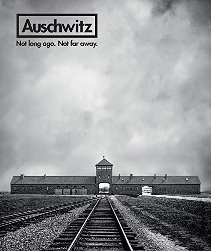 Black and white photo of Auschwitz concentration camp gate and railway tracks.