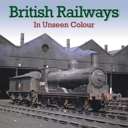 A black steam locomotive parked on tracks in front of a railway depot.