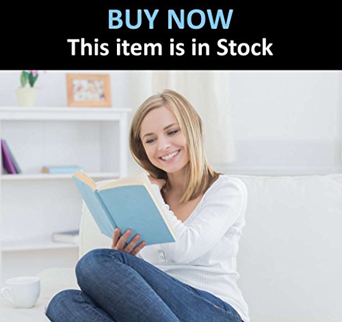 Woman reading a book on a white couch in a living room.