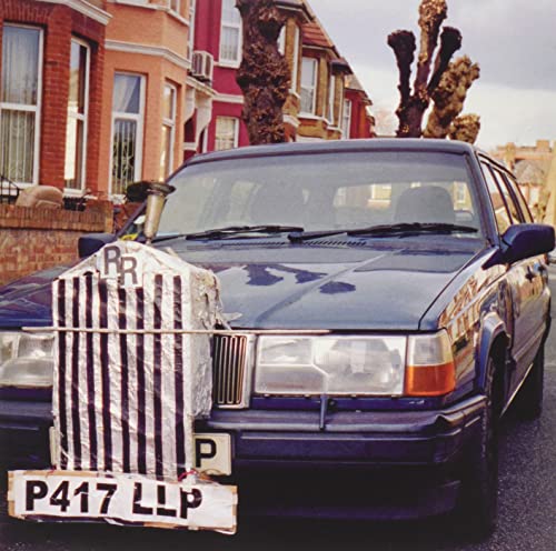 Dark blue car with a striped, makeshift grill and license plate.