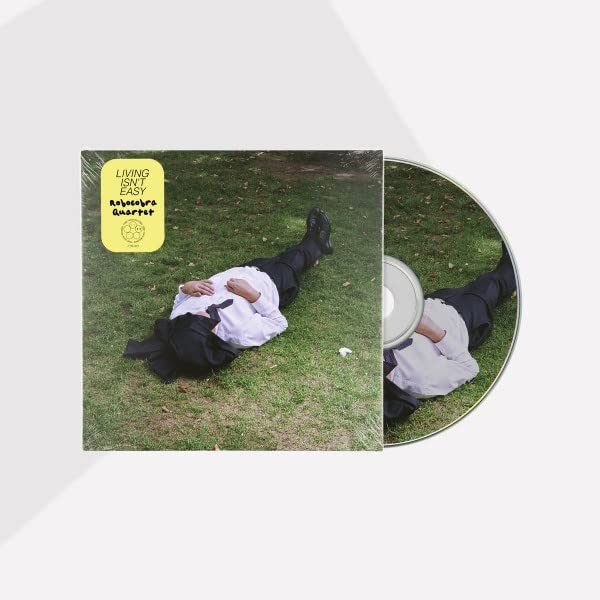 CD cover: man in suit lying in grass, legs elevated.