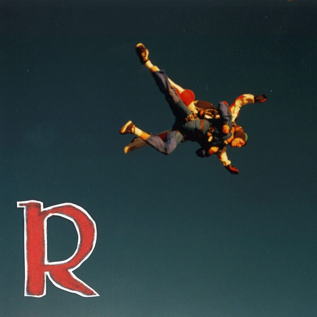 CD cover: two skydivers falling above a large red letter "R".