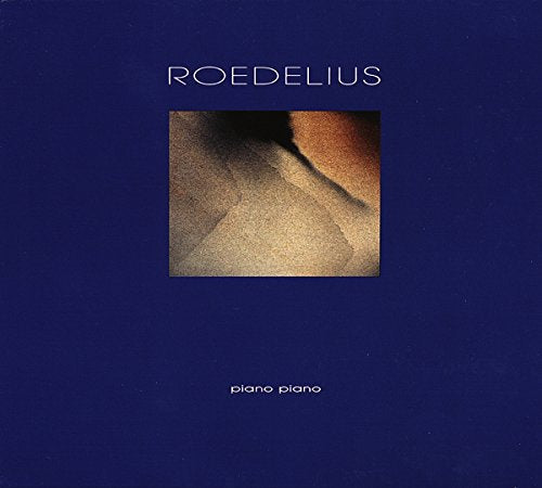 The image shows a vinyl album cover with a dark blue background. Alt text: Dark blue album cover with abstract sandy image and white text "Roedelius piano piano".