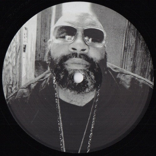 Black and white vinyl record label featuring a portrait of a bearded man.