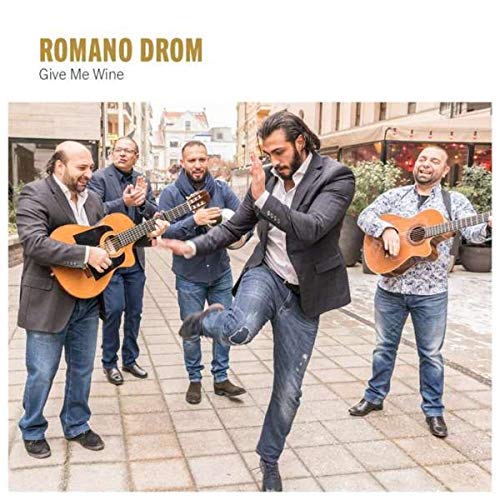 "CD cover featuring five men playing guitars on a cobblestone street, dancing."