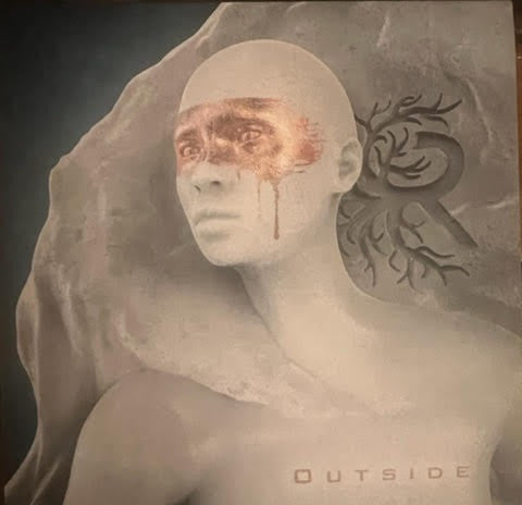 Vinyl album cover featuring a pale man with painted face and tree branches.