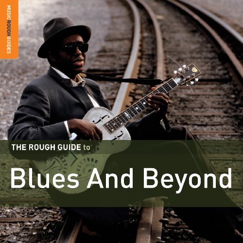 Blues musician with guitar seated on railroad tracks, album cover.