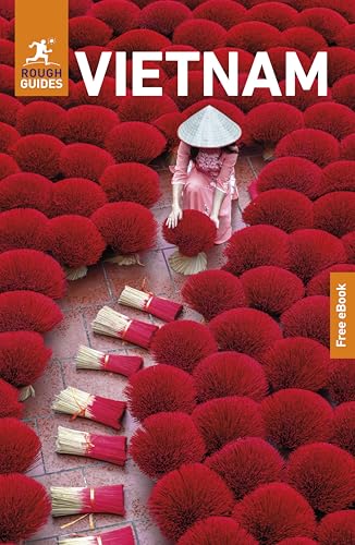 A woman in a conical hat sits among bundles of red incense sticks in Vietnam.