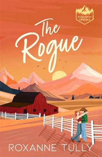 A couple embraces by a fence in front of a red barn and mountains.