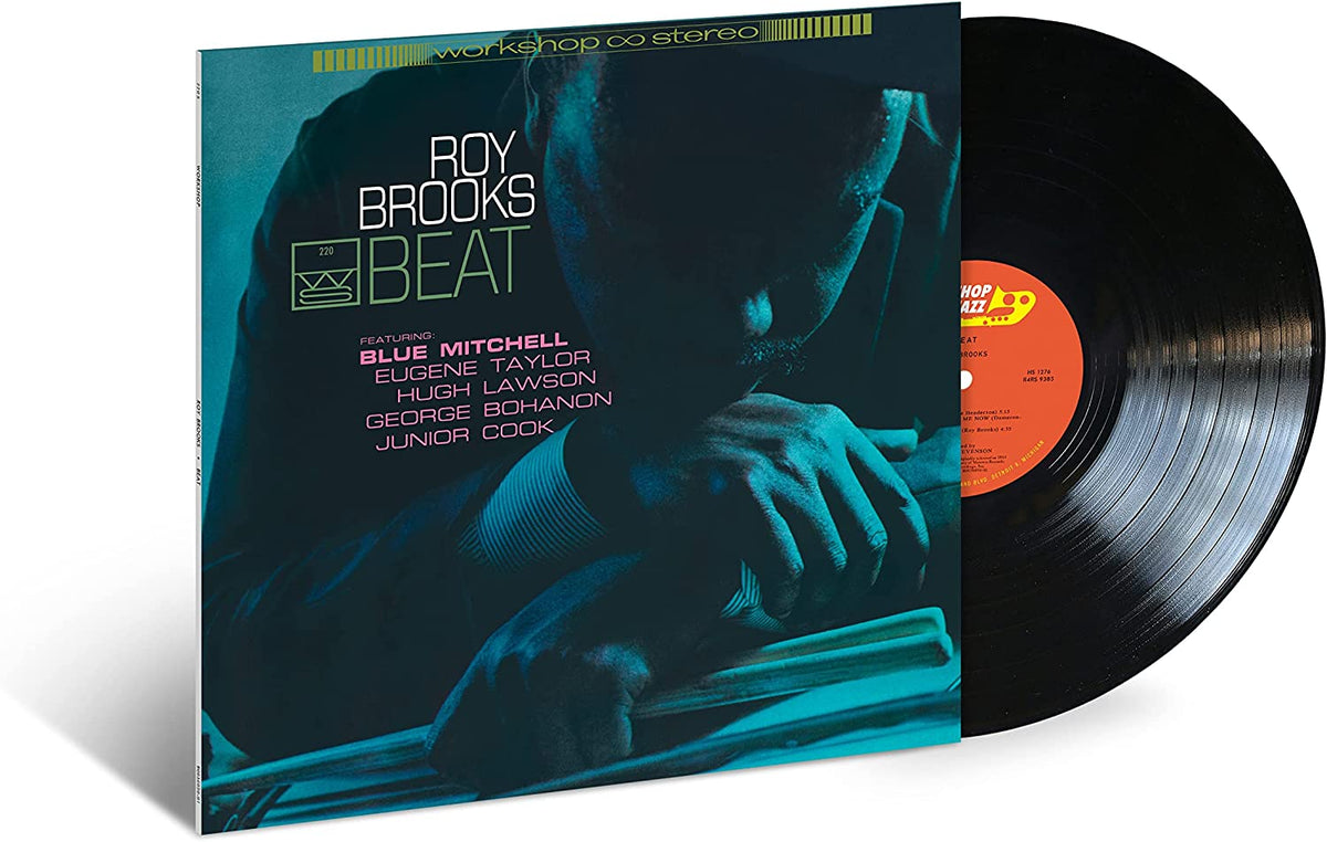 Vinyl record sleeve with a man resting on a drum kit, partially covering a black vinyl.