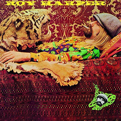 Album cover: Roy Harper with a tiger, holding a skull, on patterned fabric.