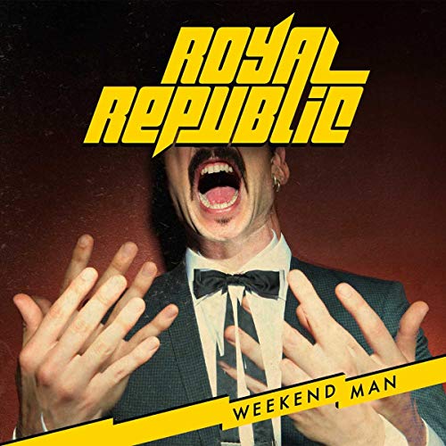 A man in a tuxedo with mouth wide open, hands raised, and yellow text overlays.