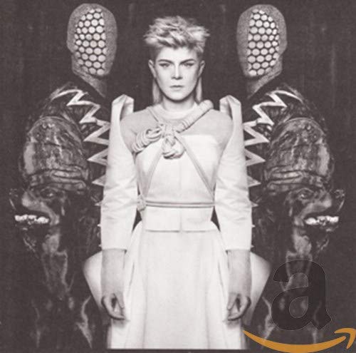 Robyn in white dress, flanked by two masked figures, grayscale image.