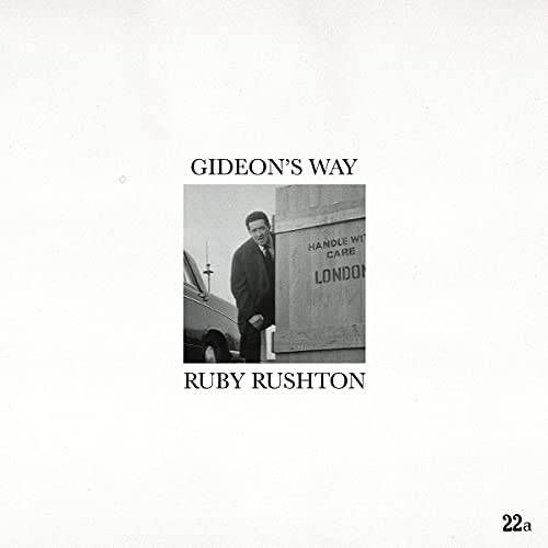 Ruby Rushton album cover: black and white photo of a man by boxes.
