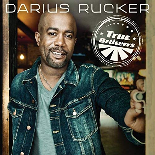 Darius Rucker portrait with album cover "True Believers" in background.