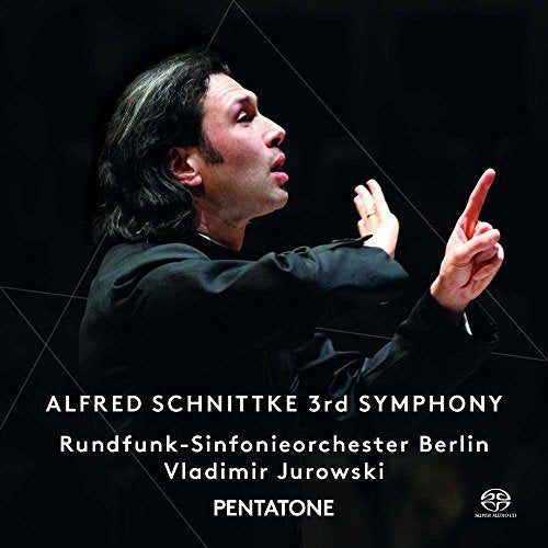 Conductor in black, arms raised, on a dark background with white text overlay.